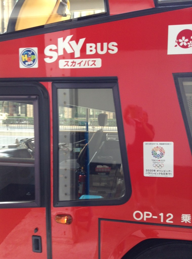 Bir tur otobüsü. Tokyo 2020 logosu özenle yerleştirilmiş