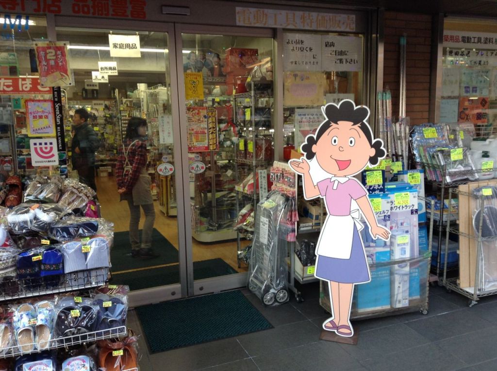 Dükkanımıza hoş geldiniz- ayağında terliği, belinde önlüğü ile Japon kadınlarını olması gereken yere, yani eve, koyan Sazae-san